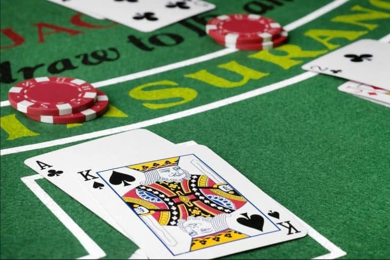 Mobile phone displaying a NetEnt live blackjack table with dealer and player cards visible